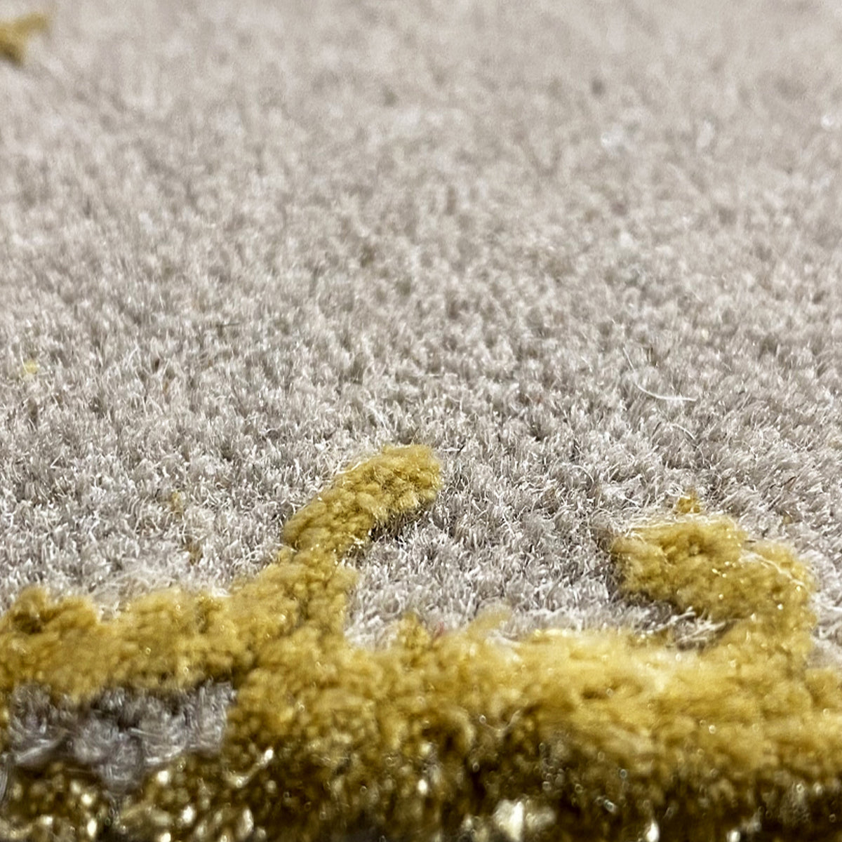 Rug detail: gray high-pile with irregular gold-colored accent areas
