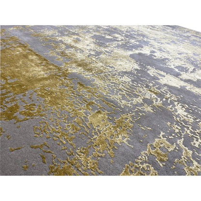 Close-up of a rug: gray-gold, mottled texture with irregular vintage effects.