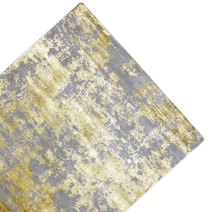 Close-up of a rug: gray areas with blurred golden pattern elements.