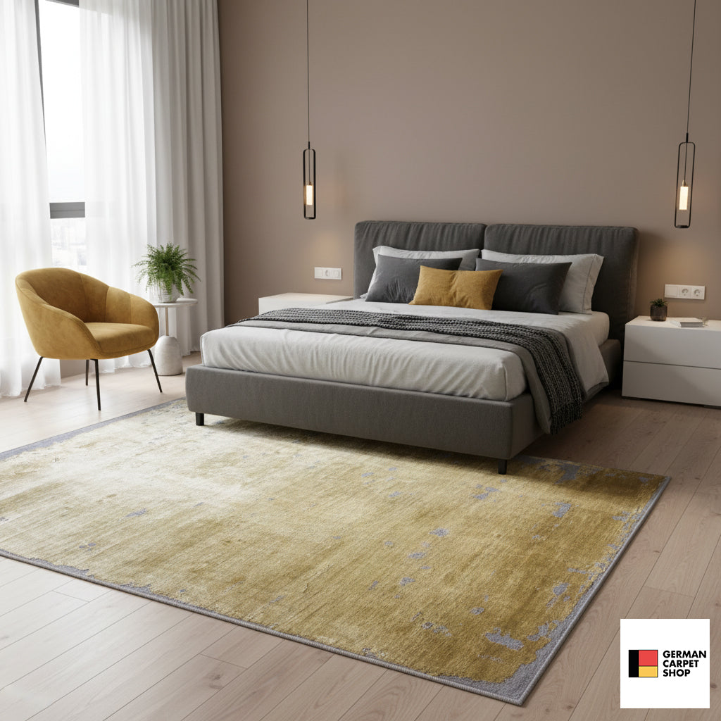 Large short-pile rug in mustard gray, with an abstract pattern and gray edging
