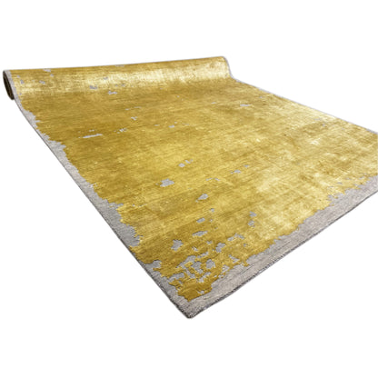 Modern yellow rug with blue-gray spots, visible edges and fold line