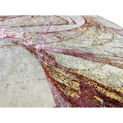 Close-up: round rug with an abstract pattern and gold and burgundy threads