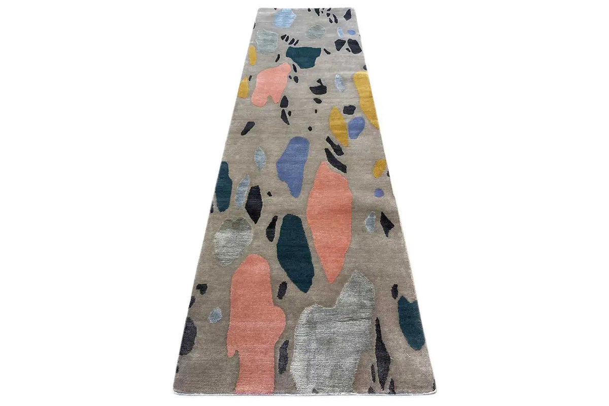 Rectangular rug with abstract color shapes in blue, coral, and yellow on gray