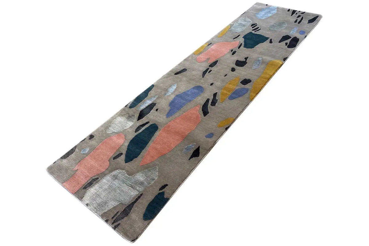 Long rectangular rug with an abstract terrazzo pattern on a light gray background