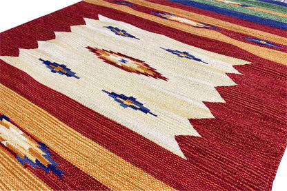 Kilim rug with a light central motif, reddish-brown borders, and colorful stripes