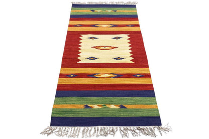 Woven rug with a zigzag pattern, reddish-brown stripes, blue and green accents, and fringe