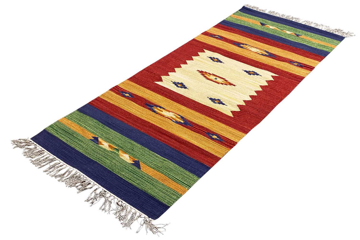 Rug with rectangular patterns in shades of red, blue, and green, diagonal view, fringes