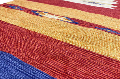 Kilim runner rug close-up: red-orange and blue stripes, dense woven fabric