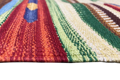 Close-up of a kilim rug: colorful woven texture with zigzag and striped patterns.