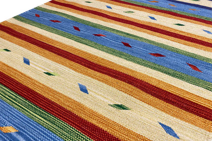 Close-up of a kilim rug with a woven texture, multicolored stripes, and dotted elements