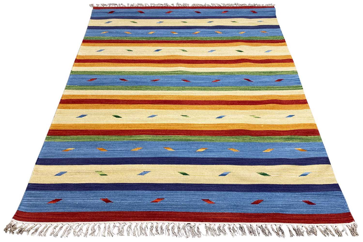 Kilim rug in beige, blue, and red with geometric patterns and fringes