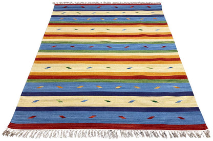 Kilim rug in beige, blue, and red with geometric patterns and fringes