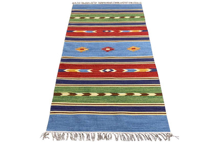 Blue kilim rug with striped patterns, colorful motifs, and fringes along the edges