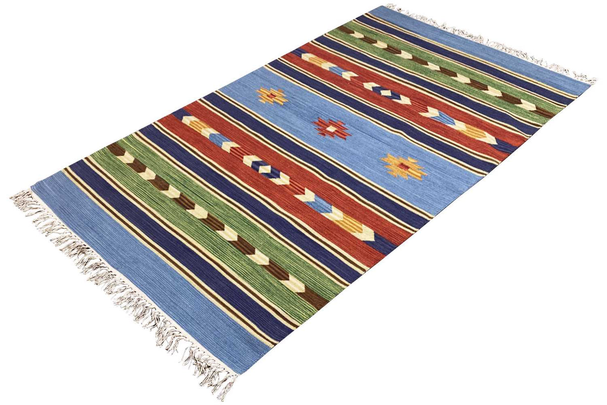 Blue pile rug with multicolored diamond and zigzag patterns, fringes along the edges
