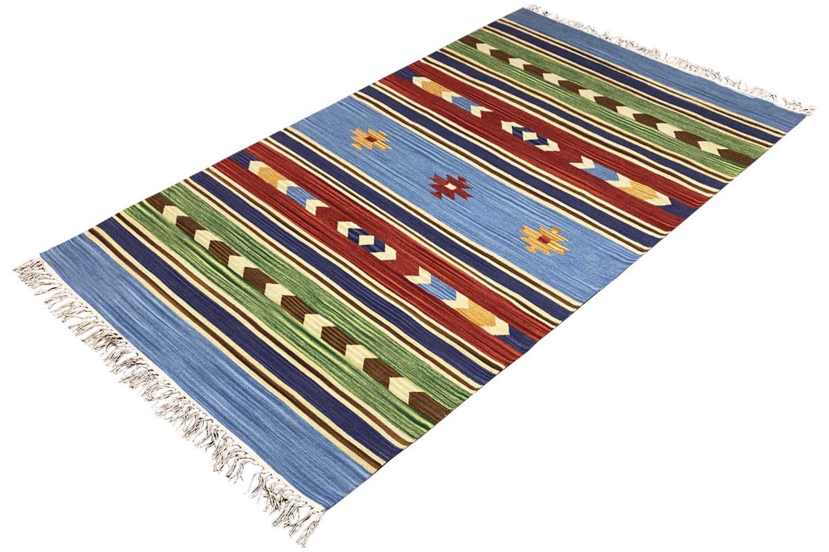 Kilim rug photographed at an angle: blue background, multicolored diamonds and stripes