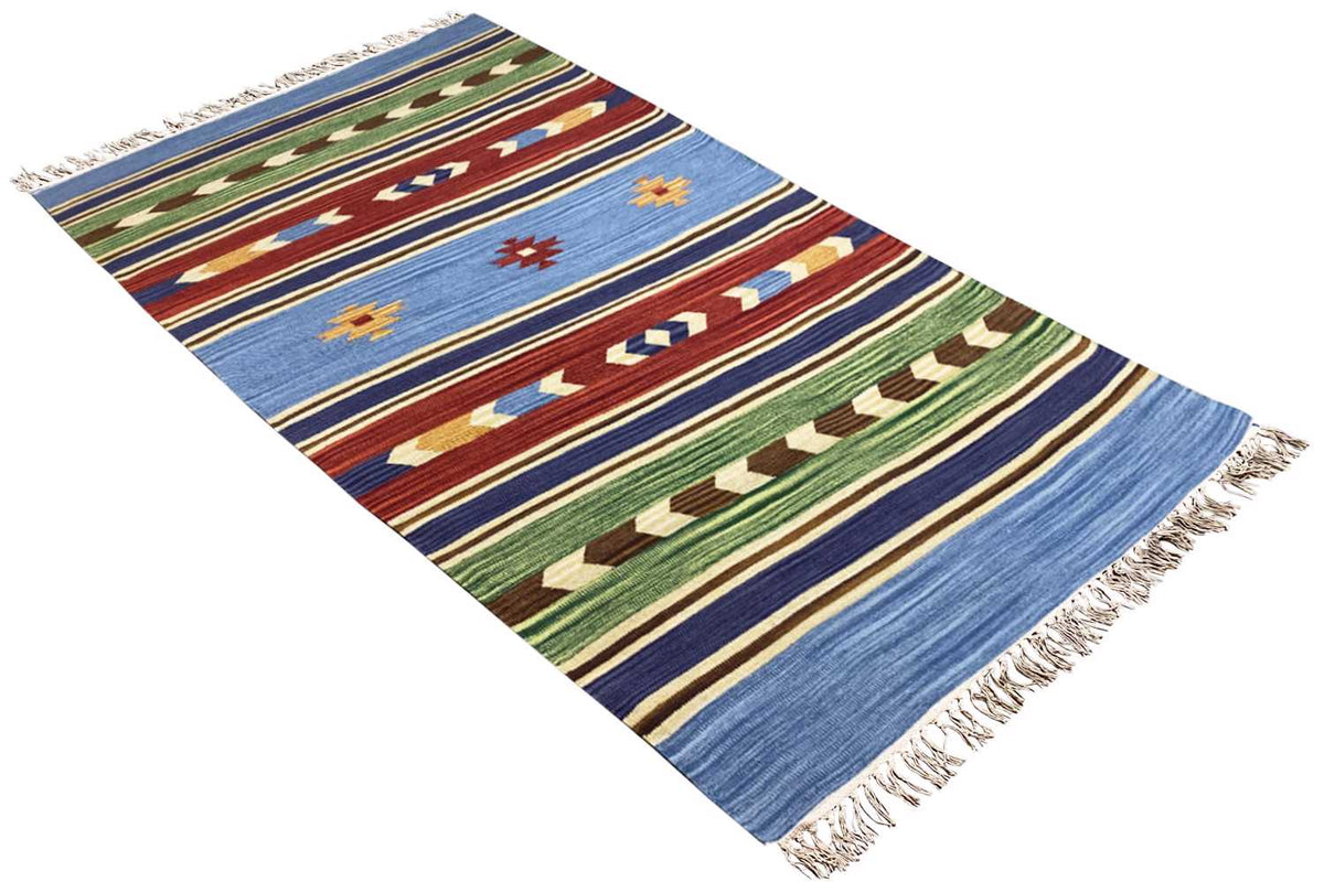 Angled kilim rug: blue background, green and red zigzag and diamond stripes