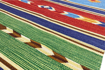 Close-up: blue kilim rug with green patterns and colorful woven ornaments