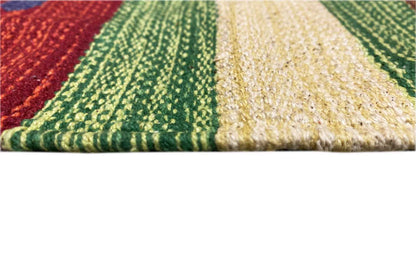 Close-up of the kilim rug: braided texture with stripes in green, red, and cream, fringes