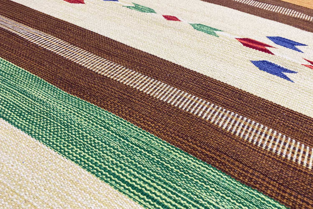Close-up: kilim weave with green, brown, and cream-colored stripes and a fine texture