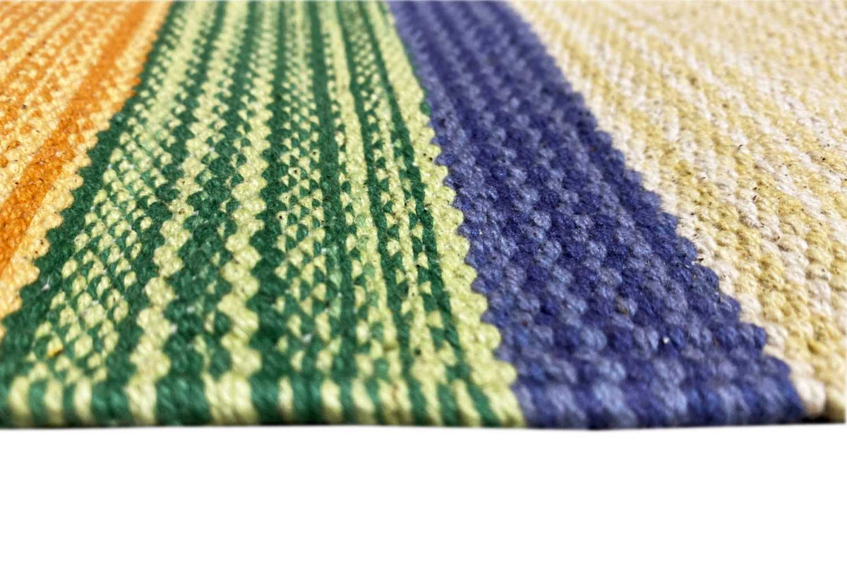 Close-up: kilim fabric with a knitted texture, green, blue, and cream accents