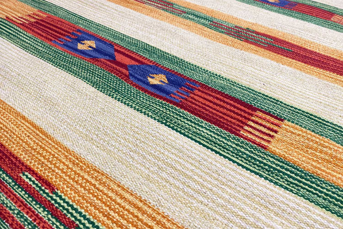 Close-up: kilim fabric with stripes in orange, green, blue, and red on cream