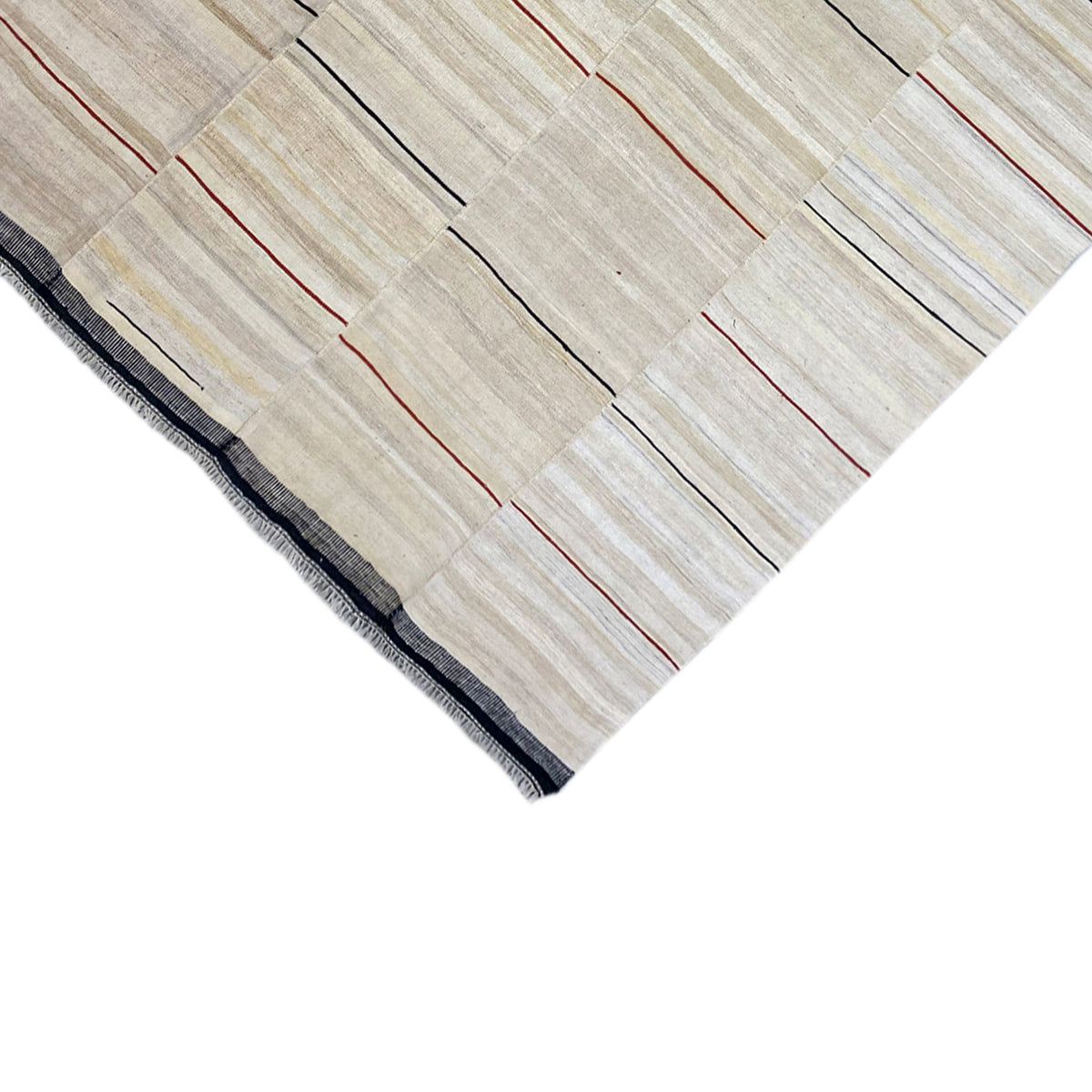 Corner of the kilim rug: beige stripes with red lines and a dark blue border