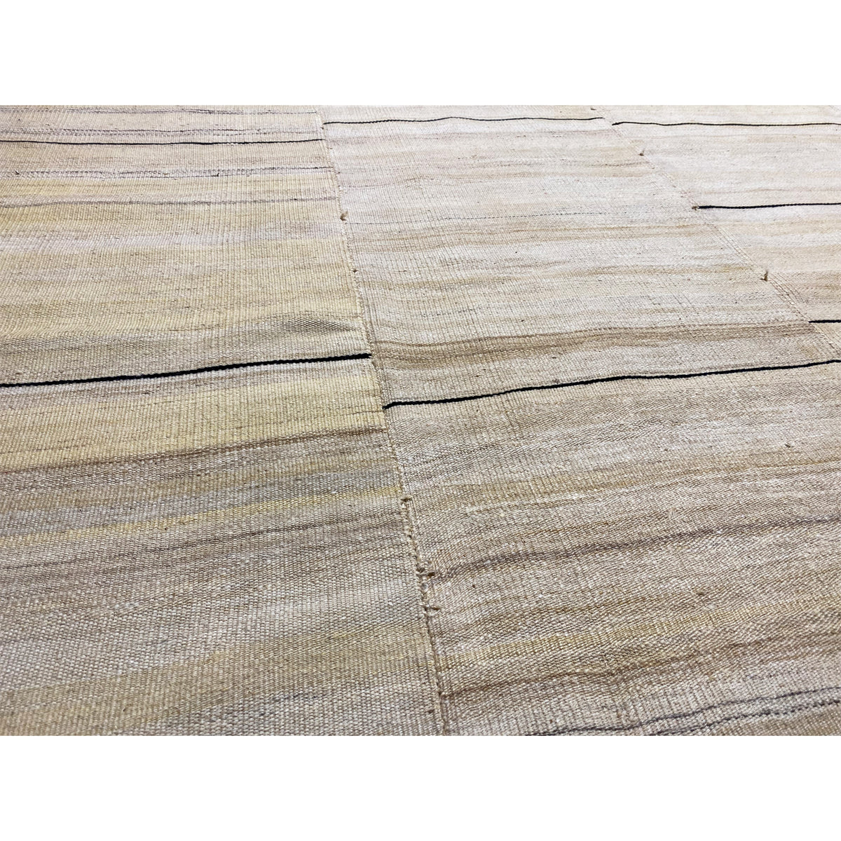 Close-up of the kilim: cream-colored fields, fine stripes, dark edges