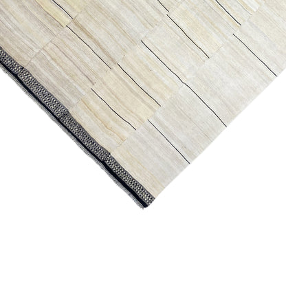 Border design: cream-colored stripes with dark gray edging and a knotted fringe