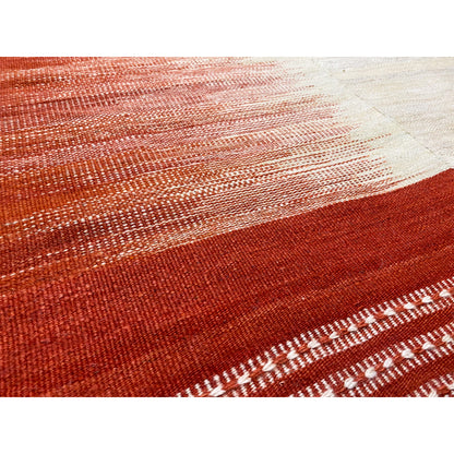 Detail of the kilim: reddish-brown fabric with a fine diamond pattern and decorative trim