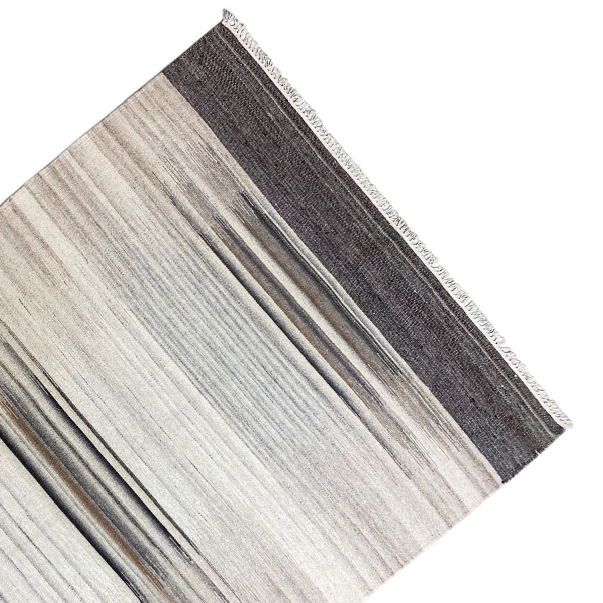 Kilim rug corner with a wide dark border and light, striped zones