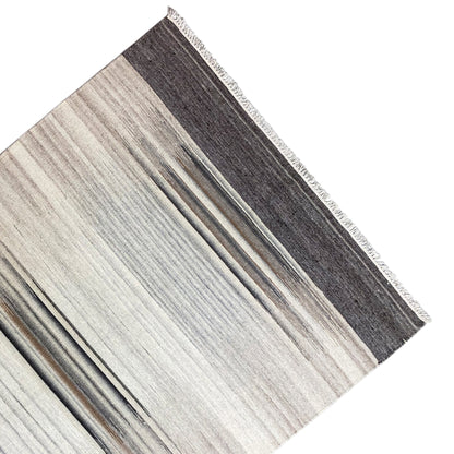 Kilim rug corner with a wide dark border and light, striped zones