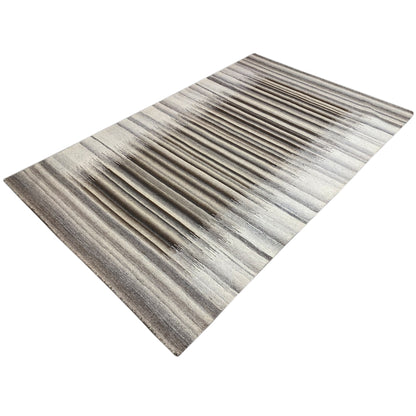 Gray rug with a regular striped pattern in gray and beige, laid diagonally