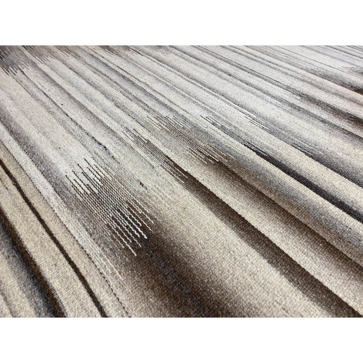 Close-up of a kilim dhurrie rug: light and dark stripes with patterned details