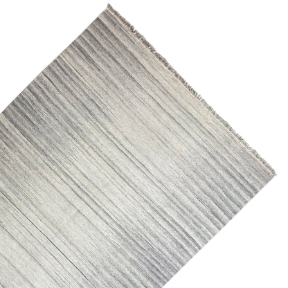 Kelim dhurrie rug detail with fine stripes and fringes along the edge