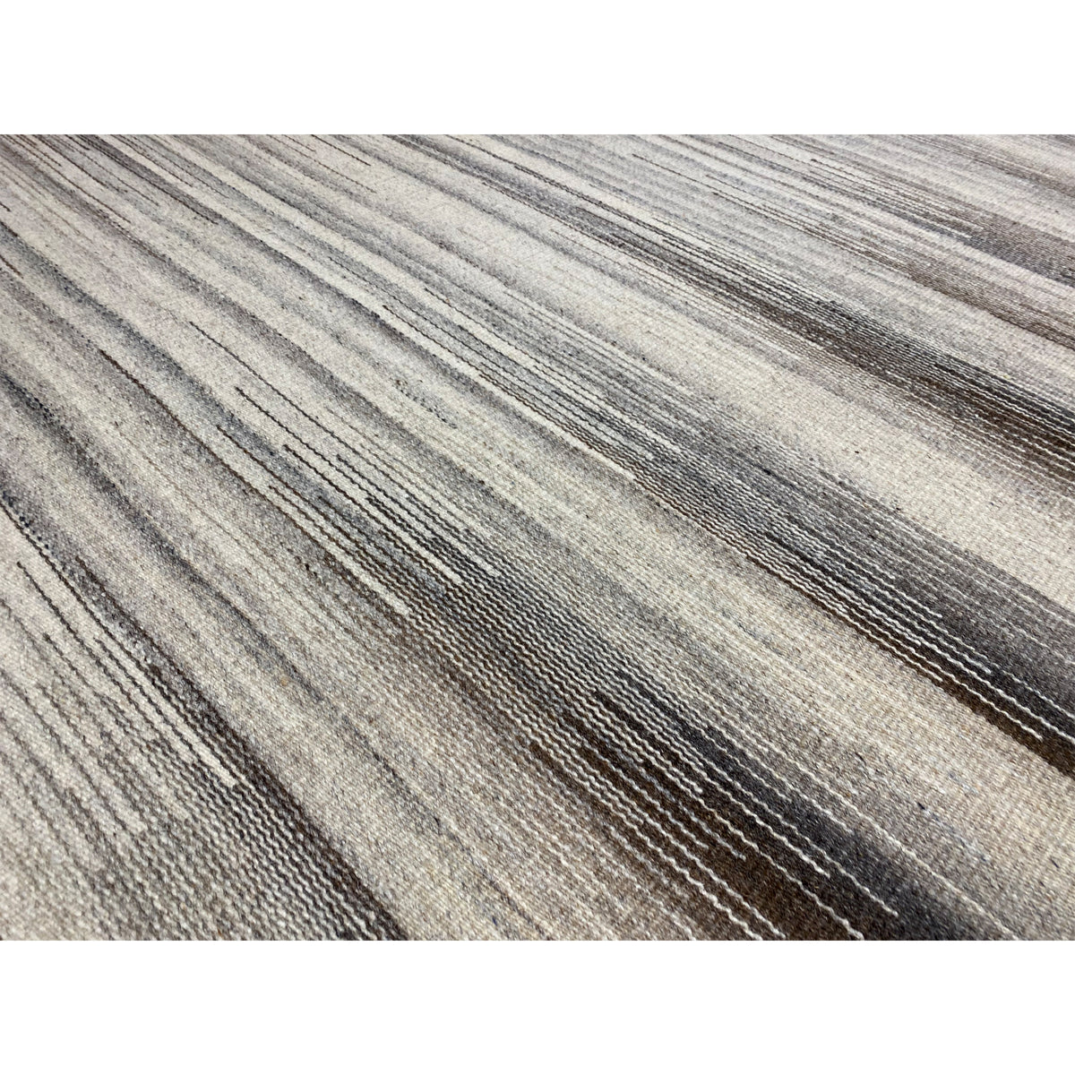 Detail of the kilim rug: fine beige and gray-brown stripes, woven texture