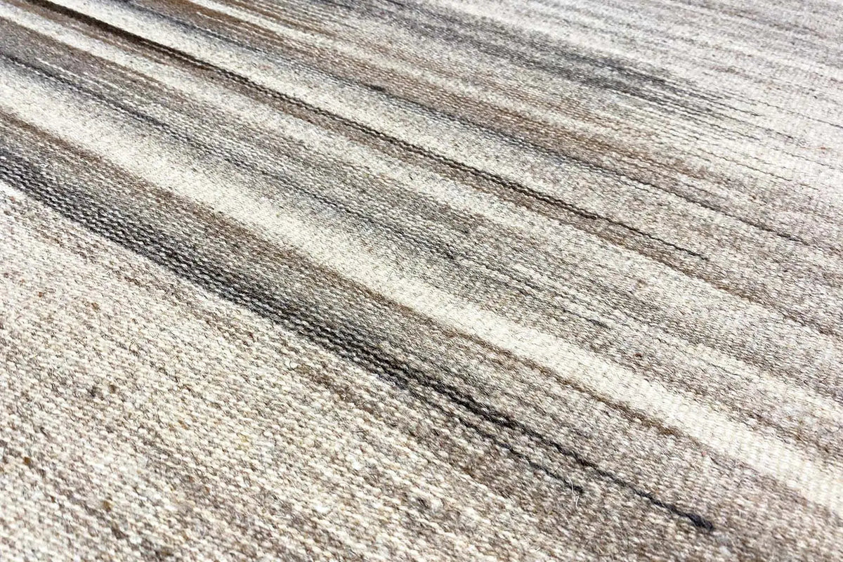 Close-up of a kilim rug: fine beige-gray stripes with dark lines