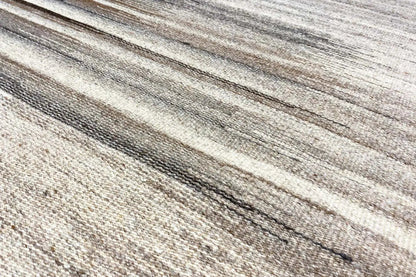 Close-up of a kilim rug: fine beige-gray stripes with dark lines