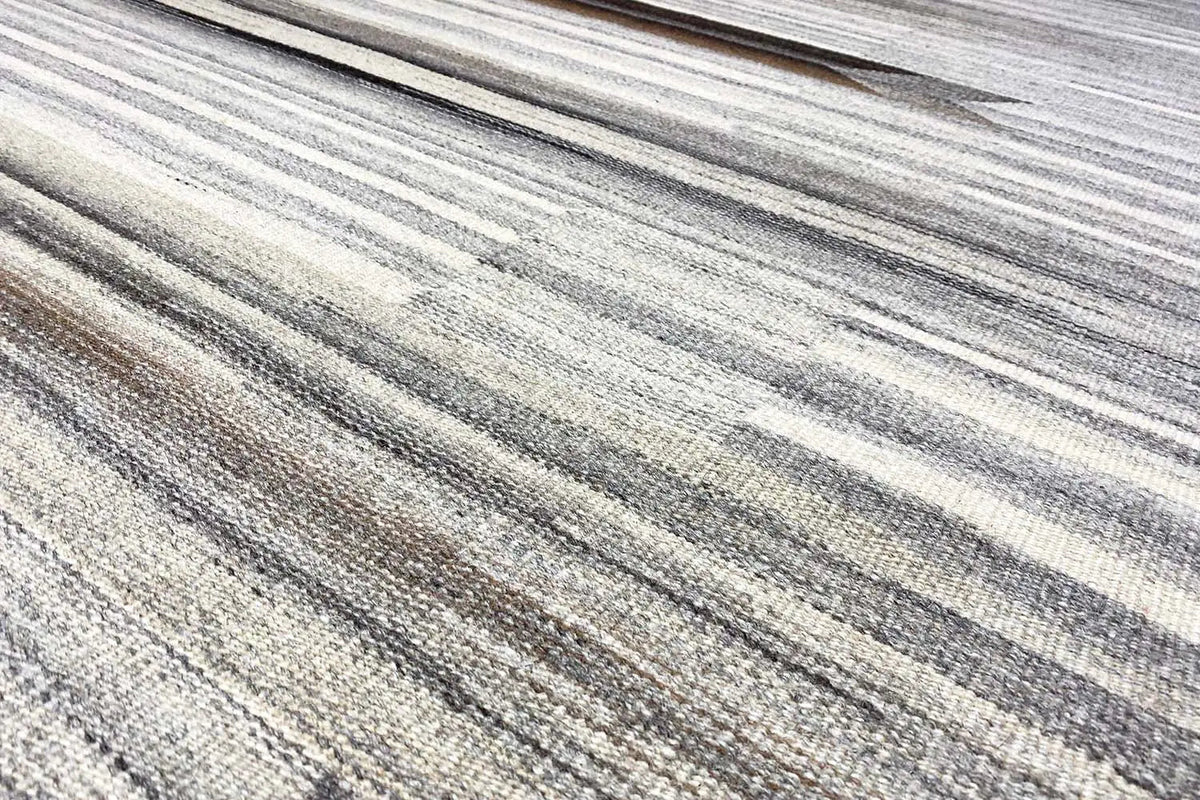 Close-up of the striped pattern on the beige and gray Kelim Dhurrie rug with darker accents