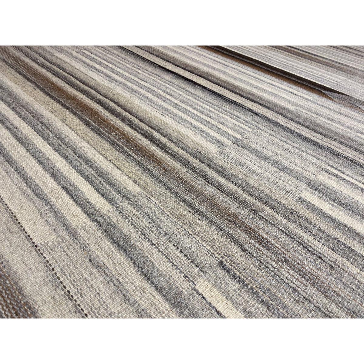 Close-up of a kilim-dhurrie rug: fine, lengthwise stripes in gray and beige