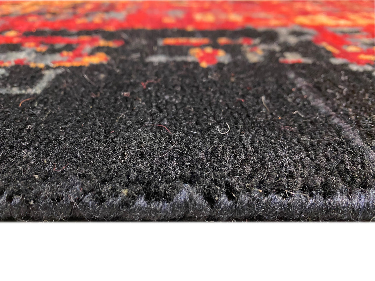 Moderner Teppich: Nahaufnahme vom Flor in Schwarz/Grau mit roten Sprenkeln und sichtbarer Struktur