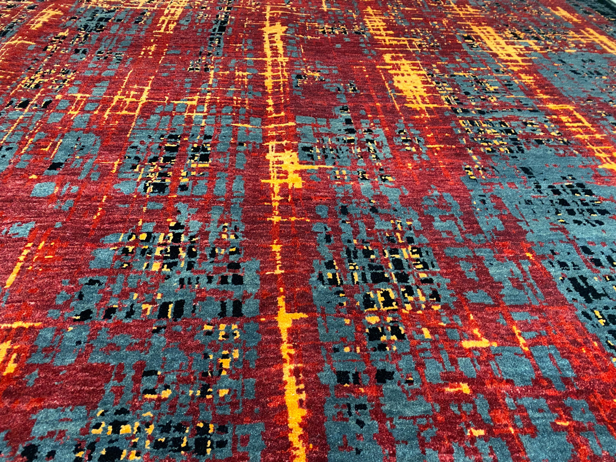 Nahansicht vom Teppich: abstraktes Raster mit Rot, Orange, Blau-Grau und schwarzen Flächen.