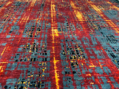 Nahansicht vom Teppich: abstraktes Raster mit Rot, Orange, Blau-Grau und schwarzen Flächen.