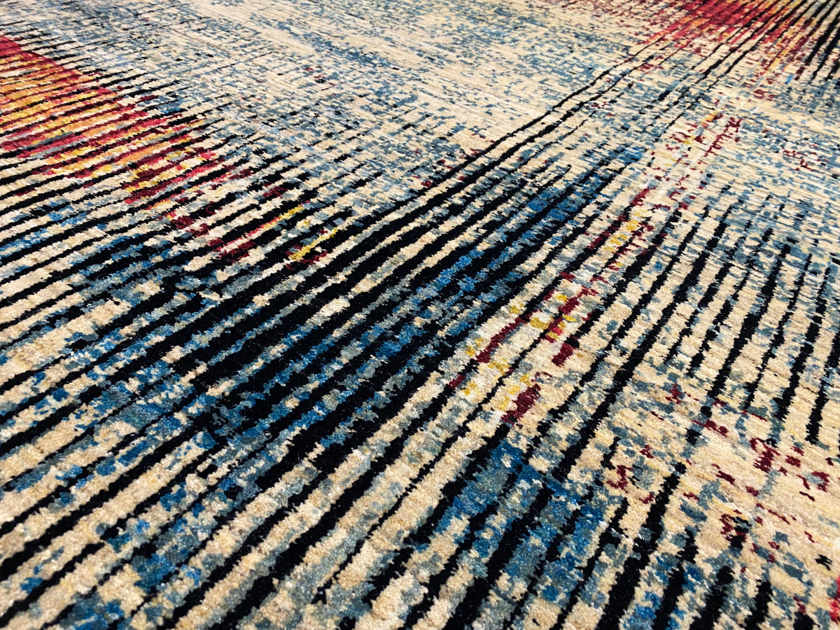 Moderner Teppich im Detail: feines Streifenmuster in Blau, Beige und Rot auf dunklem Grund