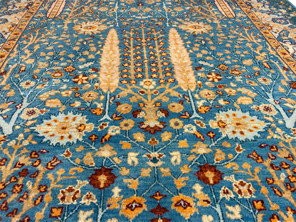 Detailaufnahme vom Teppich: blaues Ornament, orange Akzente und florale Motive im Zentrum