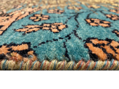 Teppichdetail: blaues Flor mit farbigen Musterlinien und goldenen Faserdetails am Rand.