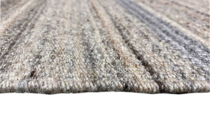 Kilim rug detail: woven surface and visible edge in mottled gray/blue