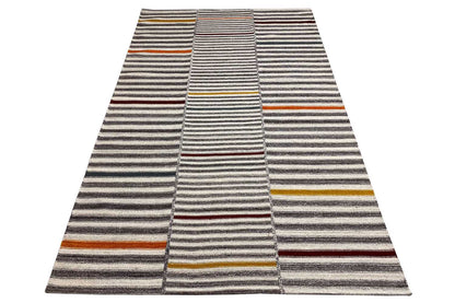 Dhurrie rug with striped bands, a gray-beige base, and multicolored accents
