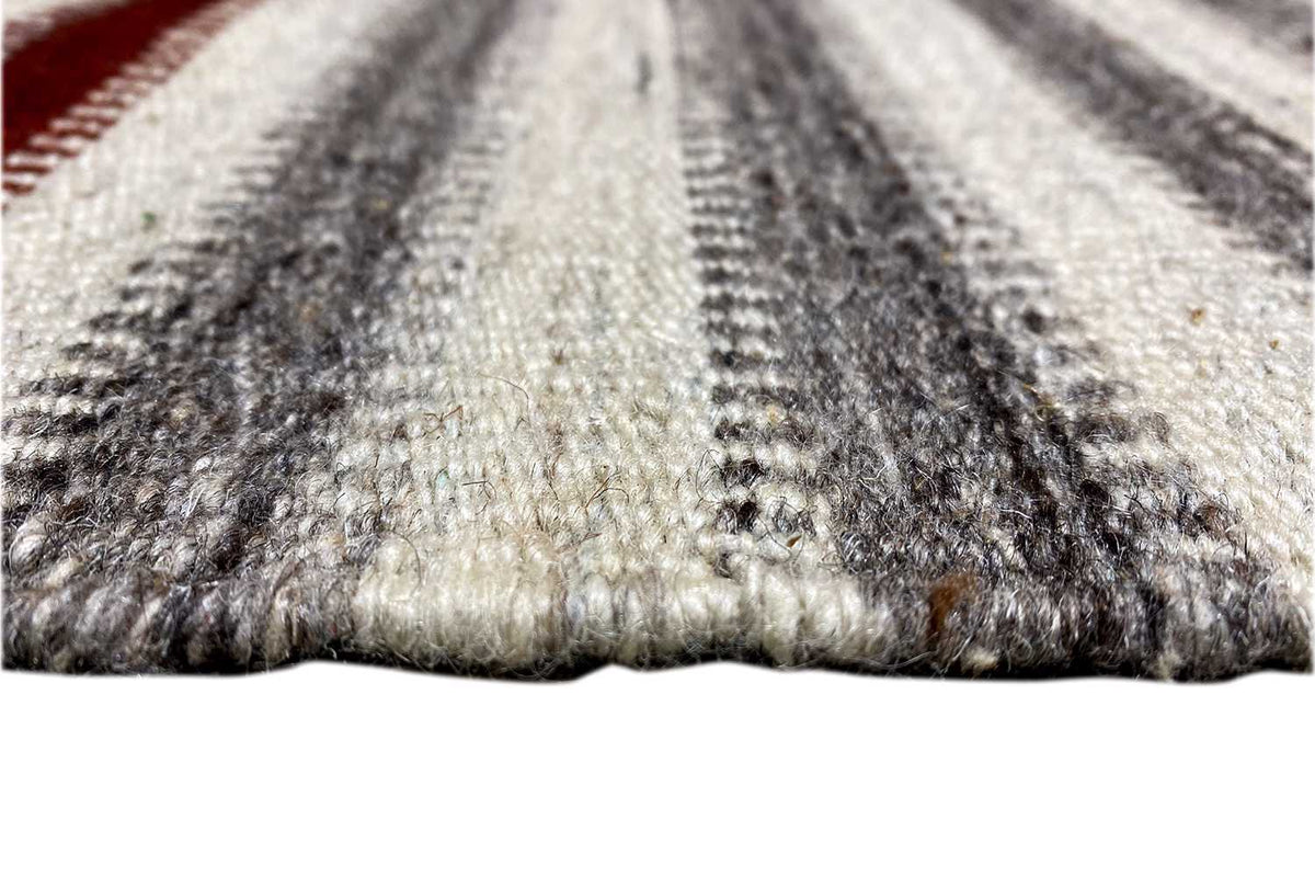 Rug edge with fringe trim, gray and beige striped pattern, mottled texture