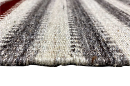 Rug edge with fringe trim, gray and beige striped pattern, mottled texture