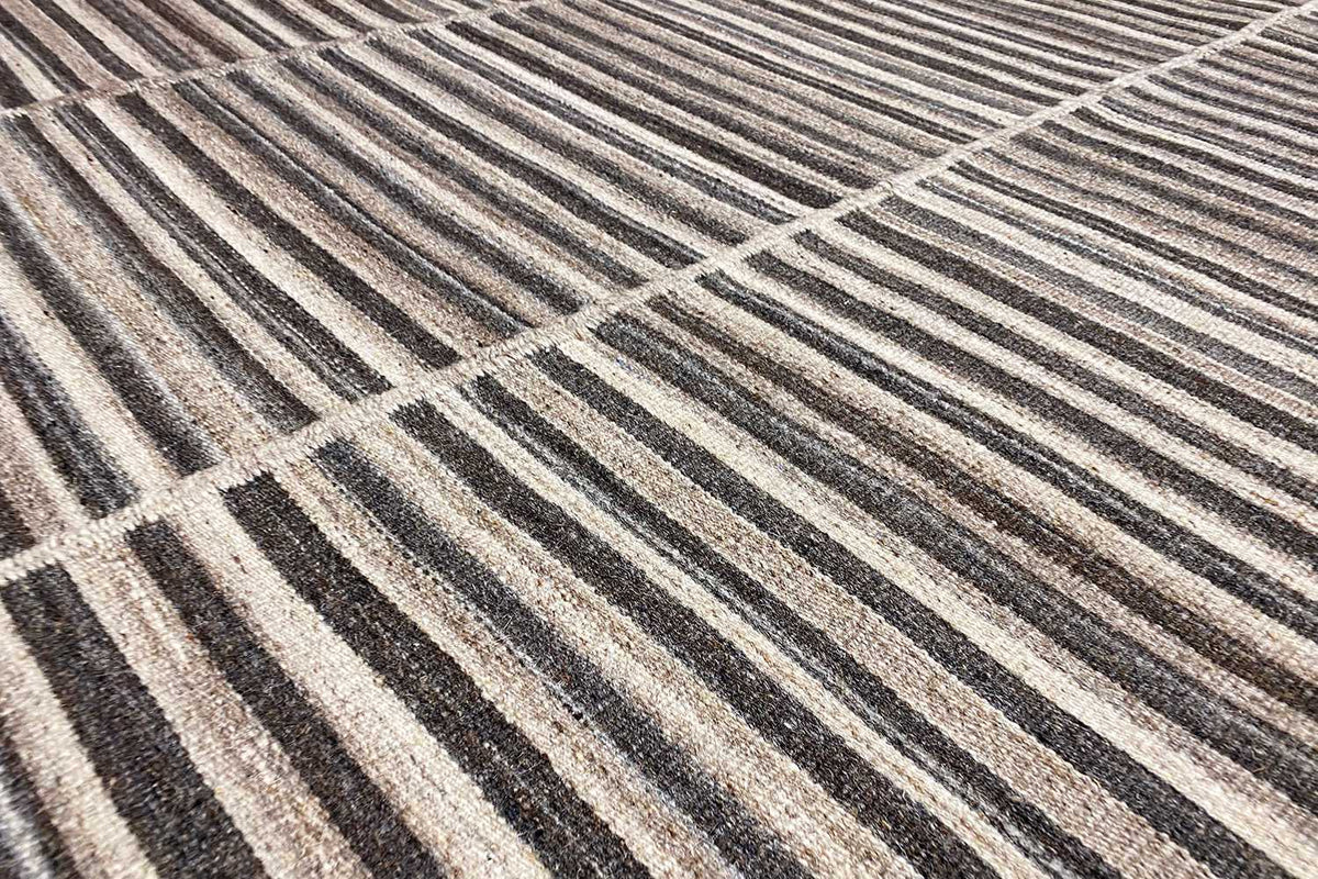 Close-up of a kilim dhurrie: woven lines in gray, brown, and beige, flat-weave